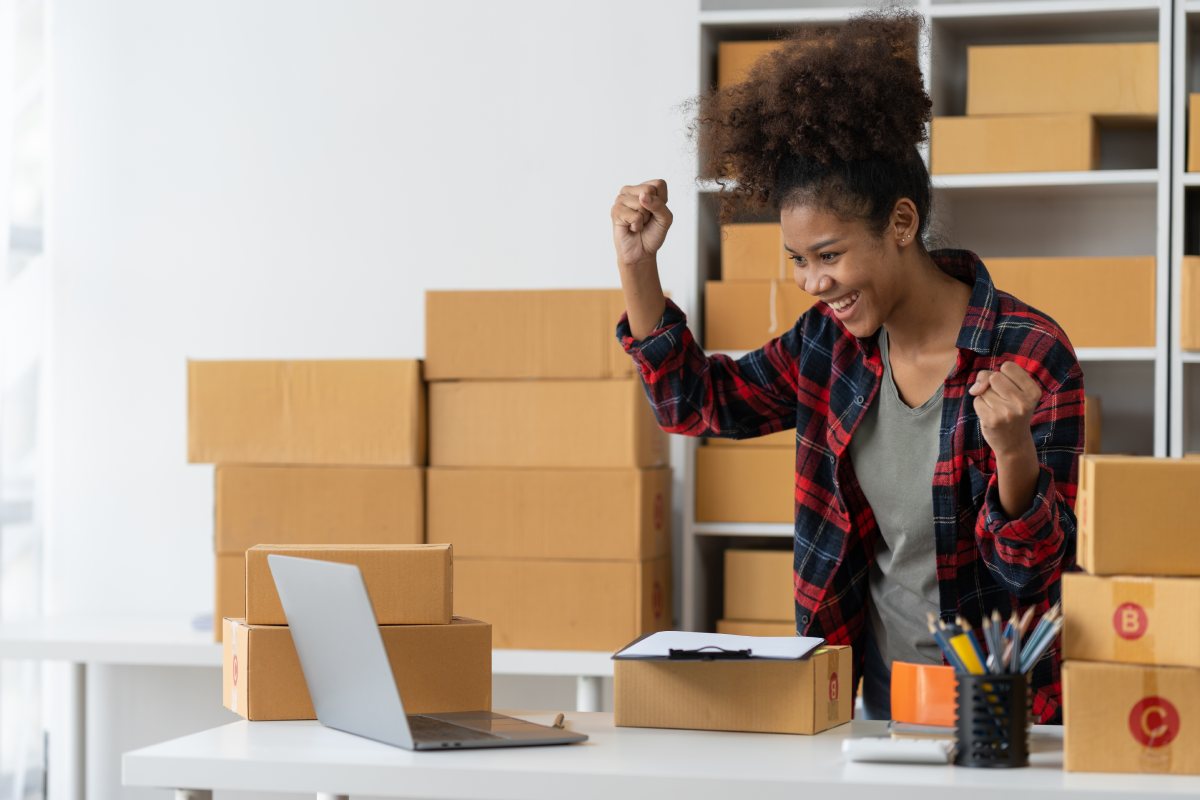 Empreendedora comemorando vendas em ambiente de e-commerce, ilustrando resultados positivos ao conquistar a Amazon Buy Box.