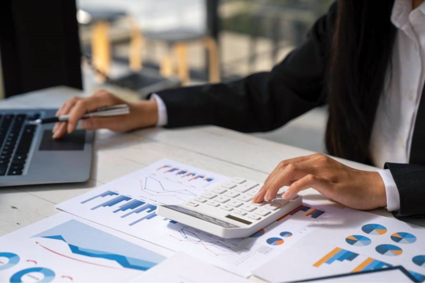 Profissional analisando dados e calculadora com gráficos de vendas, simbolizando estratégia para ganhar a Buy Box.
