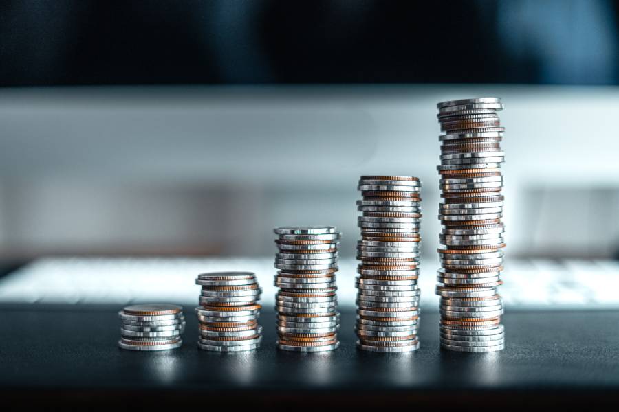 Pilhas de moedas representando estratégias de precificação em marketplace para aumento da rentabilidade.