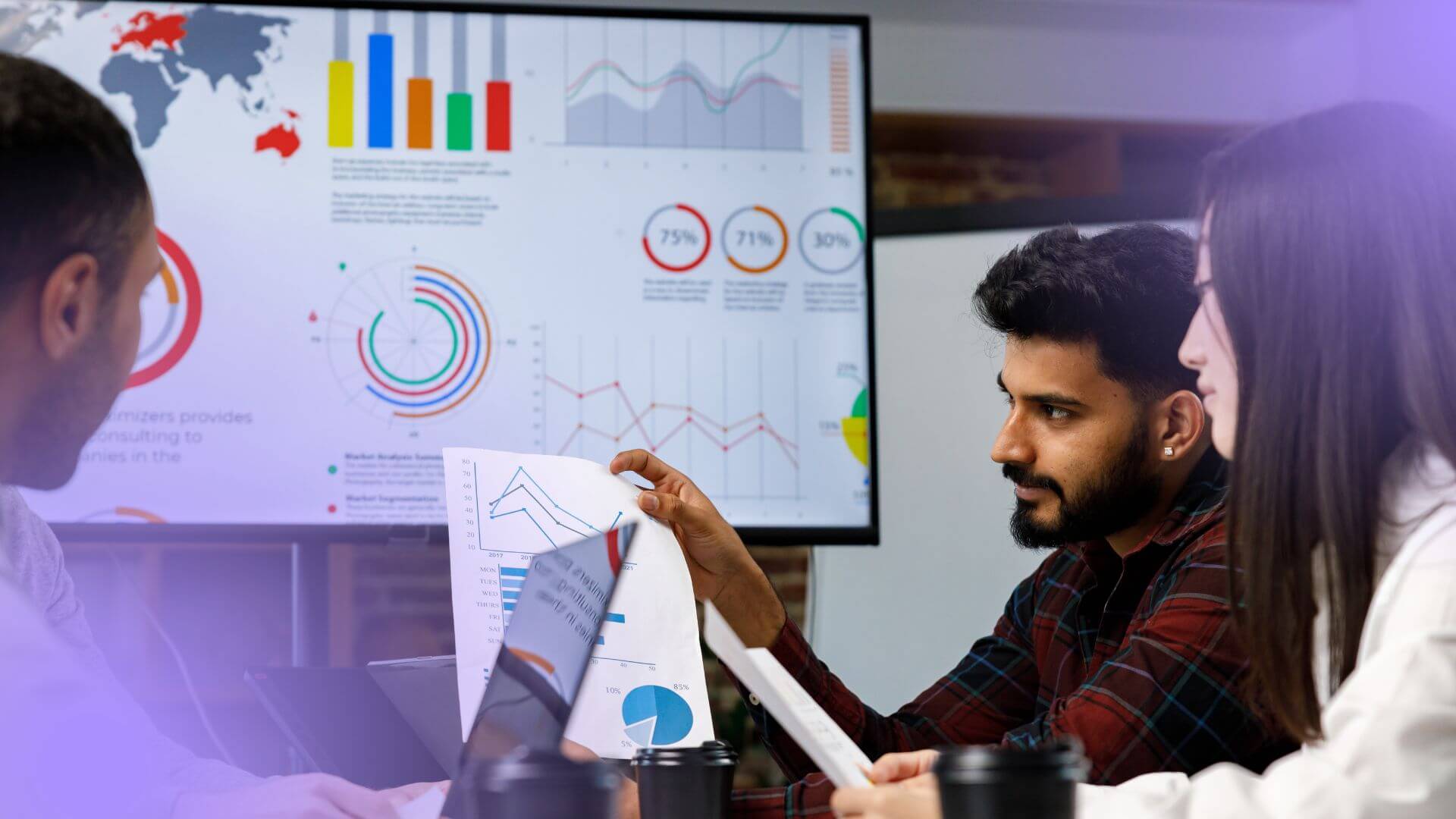 Profissionais discutindo dashboard com gr&aacute;ficos durante an&aacute;lise de concorr&ecirc;ncia para estrat&eacute;gia de escala em marketplace.
