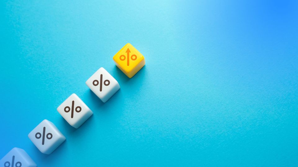 Dados em cubos com símbolo de percentual e seta para cima ilustrando elasticidade-preço da demanda em marketplace
