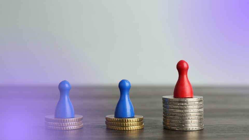 Peões sobre pilhas de moedas em alturas diferentes, representando as margens ao precificar produtos em promoção.